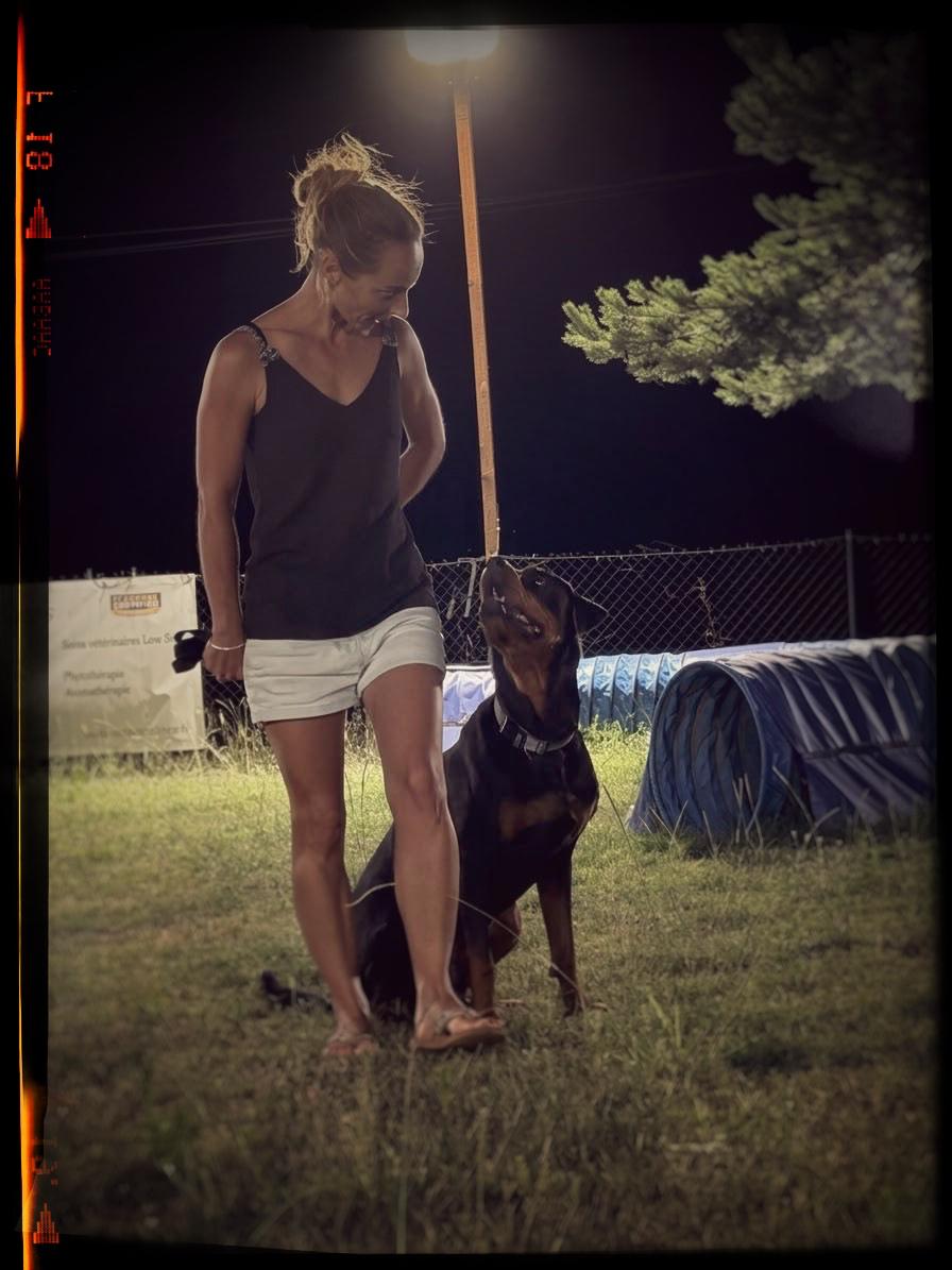 Laetitia, éducatrice comportementaliste canine, avec un rottweiler attentif Laetitia, éducatrice comportementaliste canine, avec un rottweiler attentif
